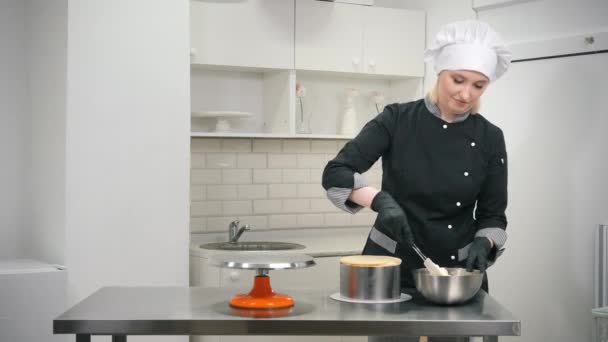 Žena v černé uniformě připravuje krém na zdobení dortu — Stock video