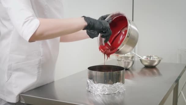 Γυναίκα ρίχνει κόκκινη ζύμη στο ταψί στο τραπέζι στην κουζίνα — Αρχείο Βίντεο