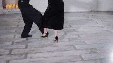 Bayan ve erkek stüdyoda zarif figürlerle ateşli tango yapıyorlar.