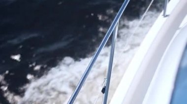 Metal tırabzanlı yat okyanus boyunca beyaz suyla yol alır.