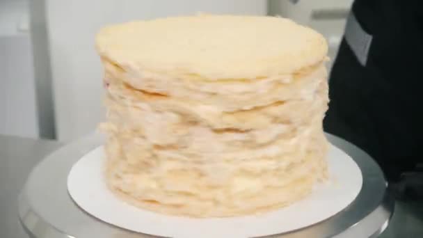 장식하지 않은 케이크가 부엌에 있는 과자 옆에서 서 있는 모습 — 비디오
