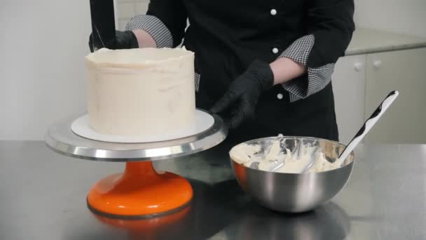 Femme en gants plaines crème douce sur le côté gâteau savoureux — Video