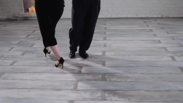 Frau im Kleid und Mann im festlichen Anzug tanzen Tango im Studio — Stockvideo
