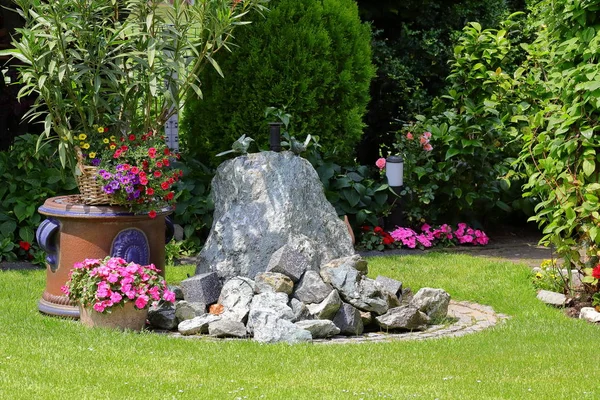 rock fountain with birds in a nicely decorated garden