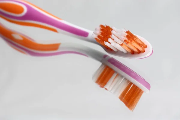 Zahnbürsten und Zahnpasta im Spiegelregal. Mundhygieneprodukte. — Stockfoto