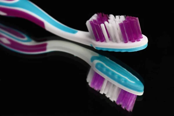 Toothbrushes and toothpaste on a mirror shelf. Oral hygiene products. — Stock Photo, Image