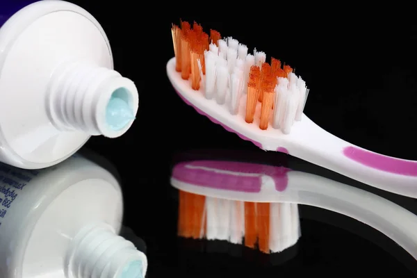Toothbrushes and toothpaste on a mirror shelf. Oral hygiene products. — Stock Photo, Image