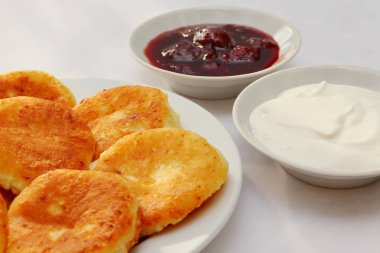 Güzel kokulu kırmızı altın kahverengi bir kabuk ile taze çilek reçeli ve ekşi krema boru sıcak şurubu curds(cheesecake) pişmiş.