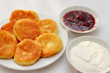 Güzel kokulu kırmızı altın kahverengi bir kabuk ile taze çilek reçeli ve ekşi krema boru sıcak şurubu curds(cheesecake) pişmiş.