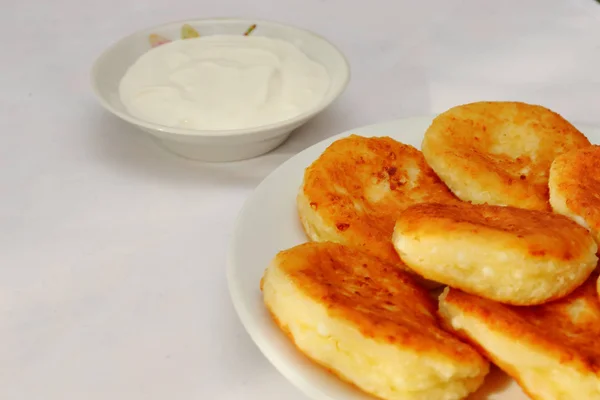 Duftende rotgoldene mit einer braunen Kruste frisch gekochter Sirupquark (Käsekuchen) mit Erdbeermarmelade und saurer Sahne. — Stockfoto