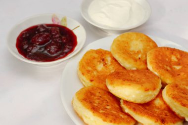 Güzel kokulu kırmızı altın kahverengi bir kabuk ile taze çilek reçeli ve ekşi krema boru sıcak şurubu curds(cheesecake) pişmiş.