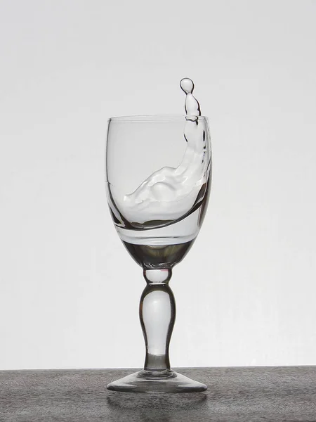 Spray liquid (clear water, red wine) from a glass goblet. — Stock Photo, Image