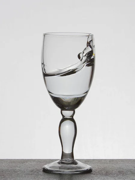 Spray liquid (clear water, red wine) from a glass goblet. — Stock Photo, Image