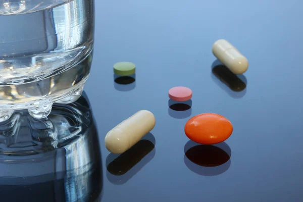 明るい着色された錠剤、丸薬、ガラス テーブルの上カプセル. — ストック写真