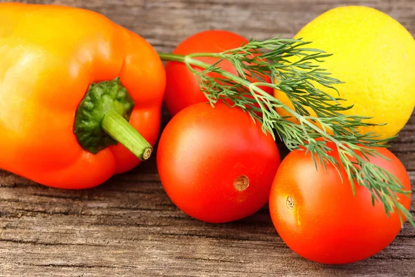 Heldere groenten en fruit (gele en oranje paprika's, rode tomaten, gele citroen, groene Dille). — Stockfoto