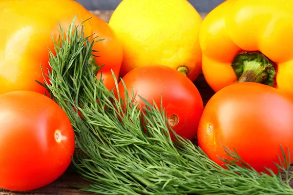 Φωτεινό λαχανικά και φρούτα (κίτρινα και πορτοκαλί πιπεριές, κόκκινες ντομάτες, κίτρινο λεμόνι, πράσινο άνηθο). — Φωτογραφία Αρχείου