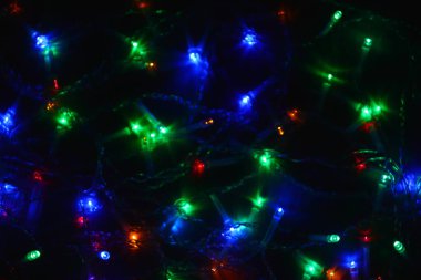 Karanlıkta renkli ışıklar (çelenk). Bokeh efekti şenlikli aydınlatma.