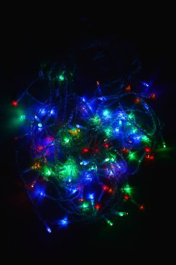 Karanlıkta renkli ışıklar (çelenk). Bokeh efekti şenlikli aydınlatma.