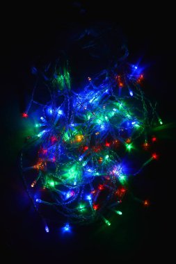 Karanlıkta renkli ışıklar (çelenk). Bokeh efekti şenlikli aydınlatma.