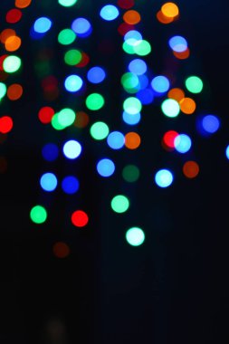 Karanlıkta renkli ışıklar (çelenk). Bokeh efekti şenlikli aydınlatma.