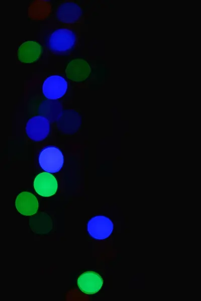 Lumières colorées (guirlande) dans l'obscurité. Effet Bokeh Eclairage festif . — Photo