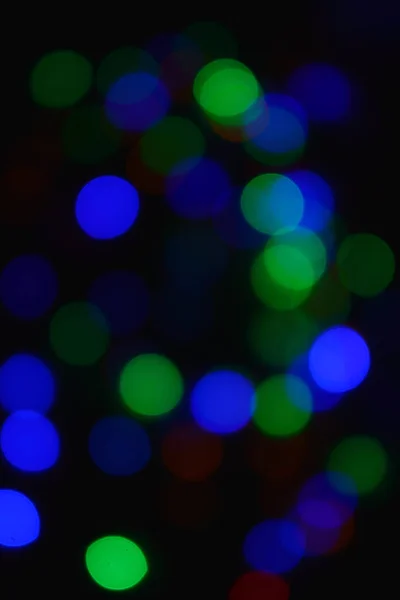 Barevná světla (Garland) ve tmě. Bokeh efekt sváteční osvětlení. — Stock fotografie