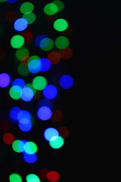 Barevná světla (Garland) ve tmě. Bokeh efekt sváteční osvětlení. — Stock fotografie