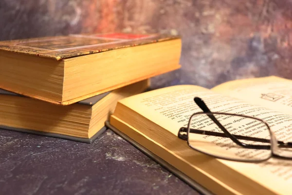 Old books, yellowed from time to time, glasses in a knitted yellow thread.