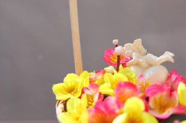 Bir sepet içinde yapay çiçekler bir buket bir kalp üzerinde beyaz melek.