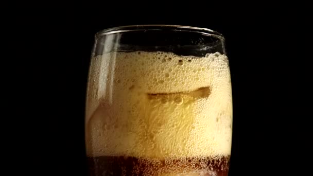 Glas med isbitar och en söt brun dryck — Stockvideo