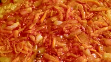 İnce doğranmış soğan ve rendelenmiş havuç bir tavada kaynar köpüren bitkisel yağ da kızartılır. Parlak turuncu kaynama kütlesi.