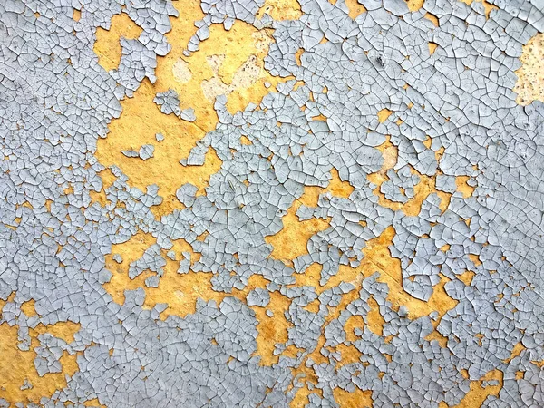 Alte rissige Wand mit in der Sonne ausgebrannten und abblätternden Farbschichten — Stockfoto