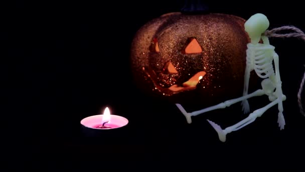 Halloween Otoño Atributos de vacaciones. Una calabaza de plástico hueco con una mueca "siniestra" tallada en ella y una vela (ledes de colores) dentro . — Vídeos de Stock
