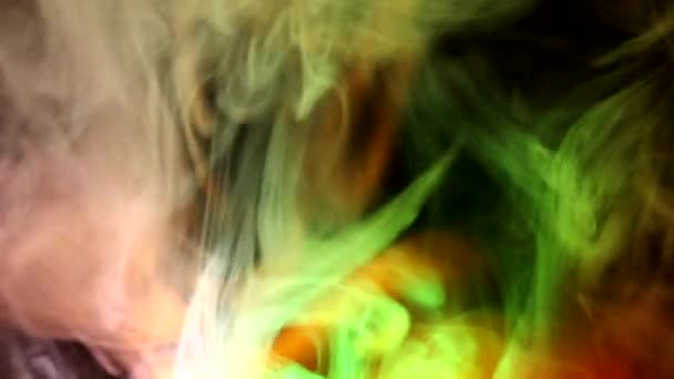 Curly creeping puffs of smoke on a dark background, illuminated by light with different colors. — Stock Video