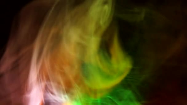 Curly creeping puffs of smoke on a dark background, illuminated by light with different colors. — Stock Video