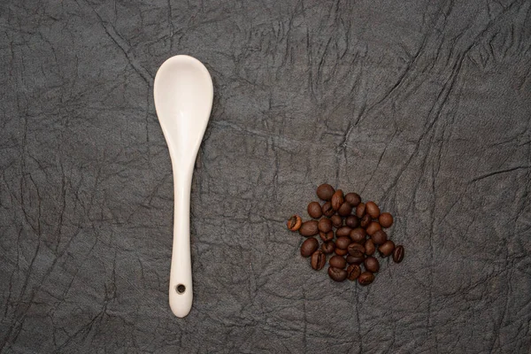 Weiß glasiertes Porzellan Kaffeelöffel auf Kunstleder Hintergrund. — Stockfoto