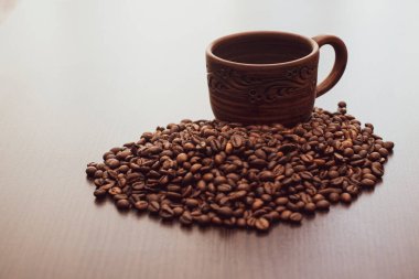 Kahverengi seramik bardak ve boyalı desenler. Kahve fincanı masanın üstünde. Boş kahve fincanı ve dağınık kahve..