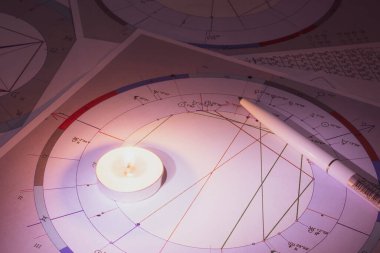 Modern bir astrologun işyeri. Bir astrologun aksesuarları. Bilgisayar astrolojik haritaları ve tabloların çıktıları. Astrolojik semboller ve işaretler.