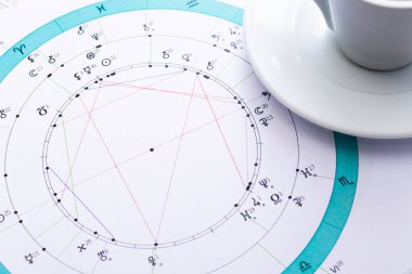 Bir astrologun masaüstü bilgisayarı. Geleceğin tahmincisinin çalışma ortamının büyülü gizemli atmosferi. Astrolojik çizelge ve tabloların çıktıları masaya saçılmış..