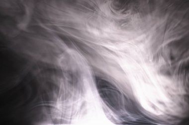 Koyu bir arka planda renkli duman bulutları. Dumanlı bir fantezi. Uçan dumanlı muğlak fanteziler.