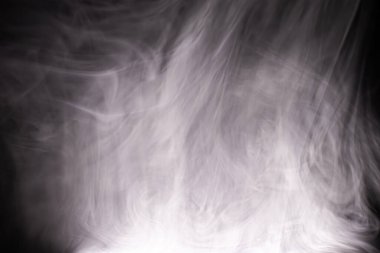 Koyu bir arka planda renkli duman bulutları. Dumanlı bir fantezi. Uçan dumanlı muğlak fanteziler.