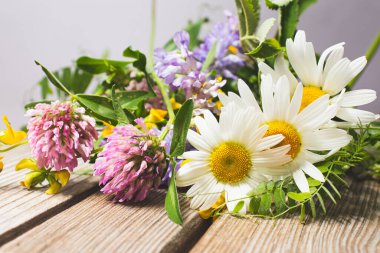 Sıcak bir yazın parlak renkleri. Yaz tarlaları, çayır otları ve ağaçtan bir bankta çiçekler..