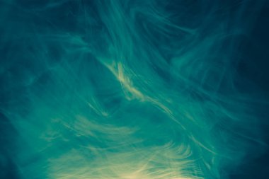 Koyu bir arka planda renkli duman bulutları. Dumanlı bir fantezi. Uçan dumanlı muğlak fanteziler.