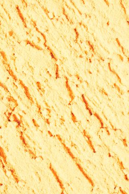 Sarı desenli alçı. Sıva kaplı bir duvar. Alçıda tek yönlü derin darbeler var..