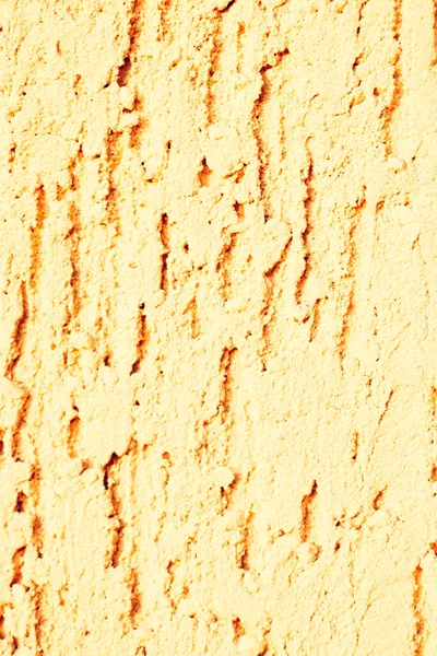 Yellow textured plaster. A plastered wall. Deep unidirectional strokes on the plaster.