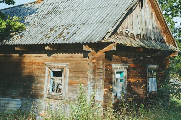 Köy malikanesinde terk edilmiş eski bir ahşap bina. Çatlak, güneş yanığı kütüklerden yapılmış bir yapı..