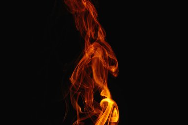 Siyah arka planda turuncu duman. Renkli duman. Duman turuncu ışıkla aydınlatılıyor. Tuhaf heceleyici alevler.