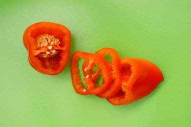 Renkli arka planda parlak portakal dilimli dolmalık meyveler. Yukarıdan bak. Düz tabaka. Yeşil arkaplan.