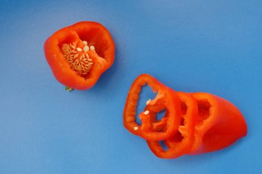 Renkli arka planda parlak portakal dilimli dolmalık meyveler. Yukarıdan bak. Düz tabaka. Mavi arkaplan.