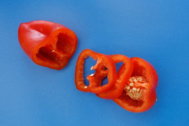 Renkli arka planda parlak portakal dilimli dolmalık meyveler. Yukarıdan bak. Düz tabaka. Mavi arkaplan.